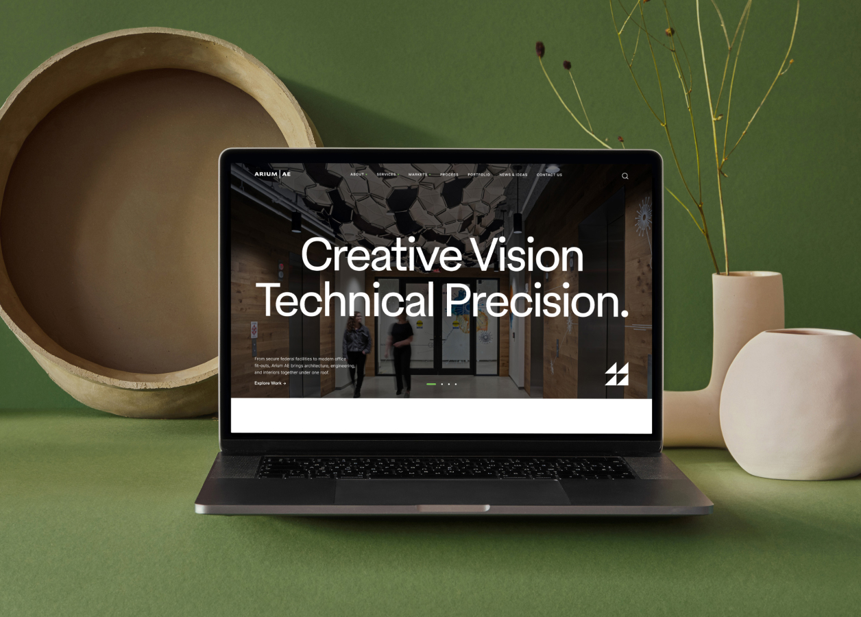 Mockup of laptop placed on a green background with beige and tan decorations surrounding it.