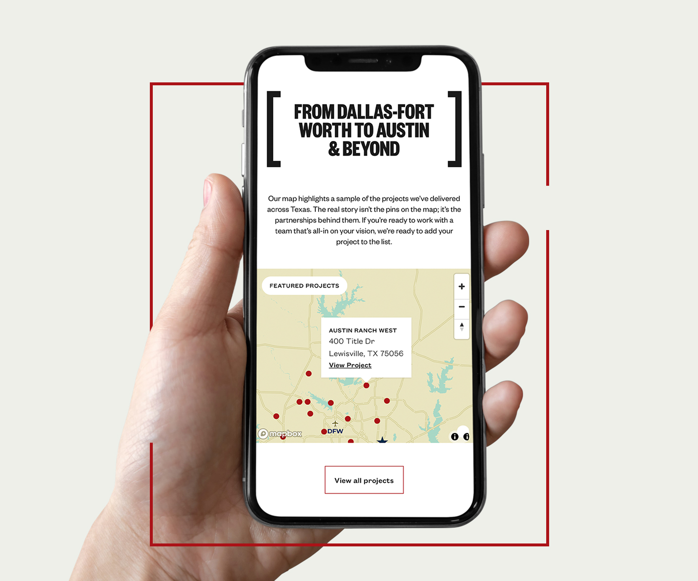 A hand holding a smartphone displaying a website with a map and text 