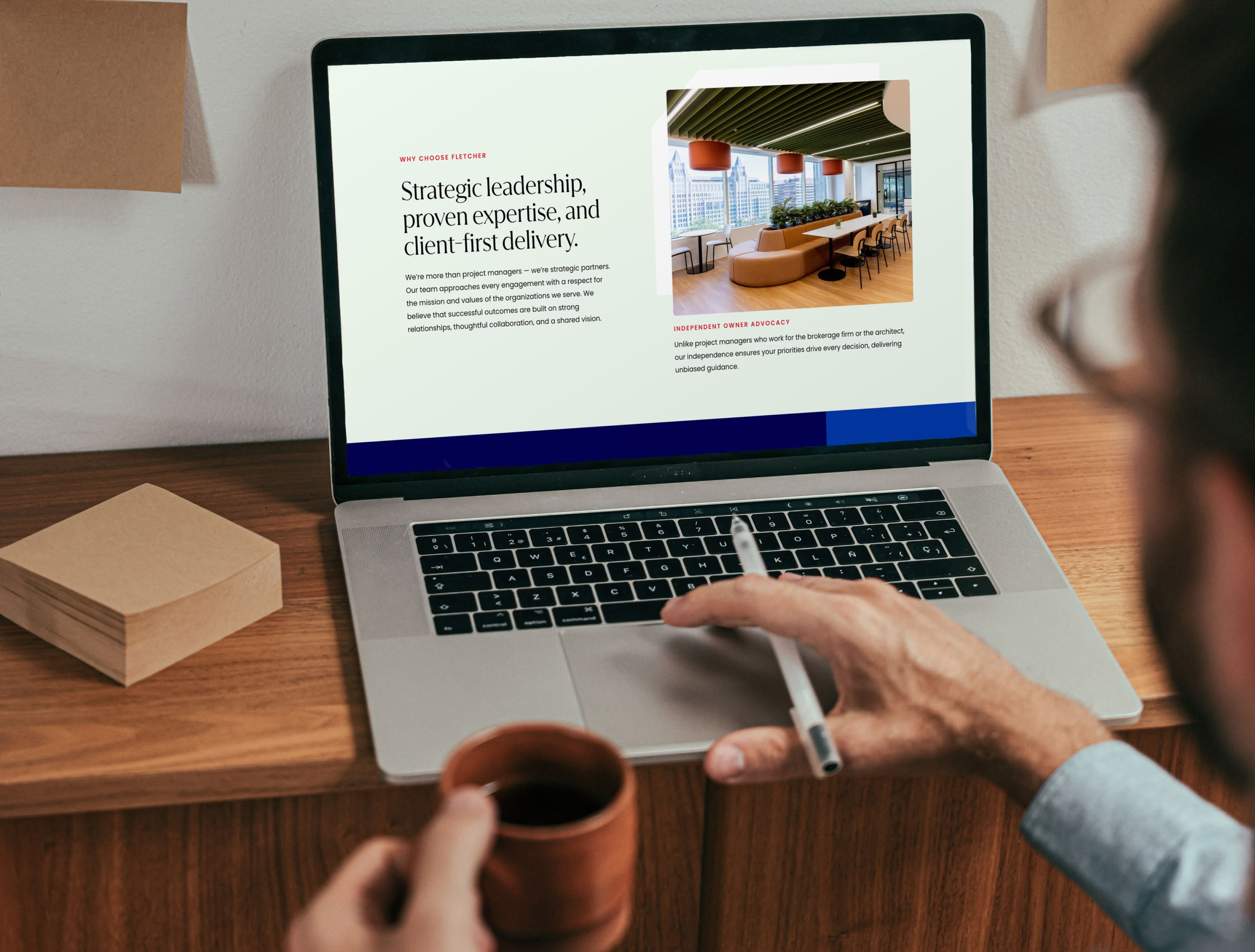 Man on computer looking at Fletcher website with coffee mug in hand